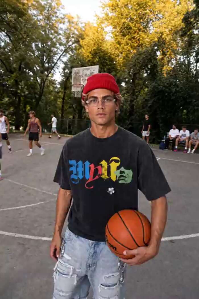 The same shorts worn on an outdoor basketball court at golden hour, the model holding a basketball.